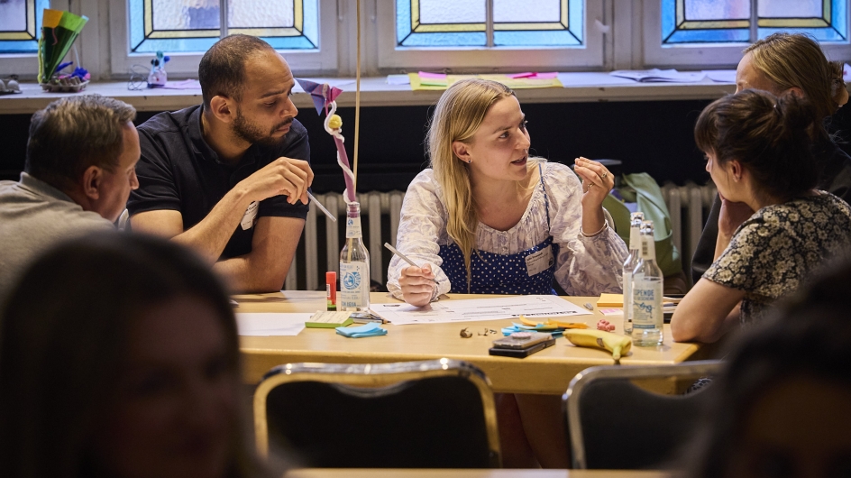 Menschen diskutieren an einem Tisch 